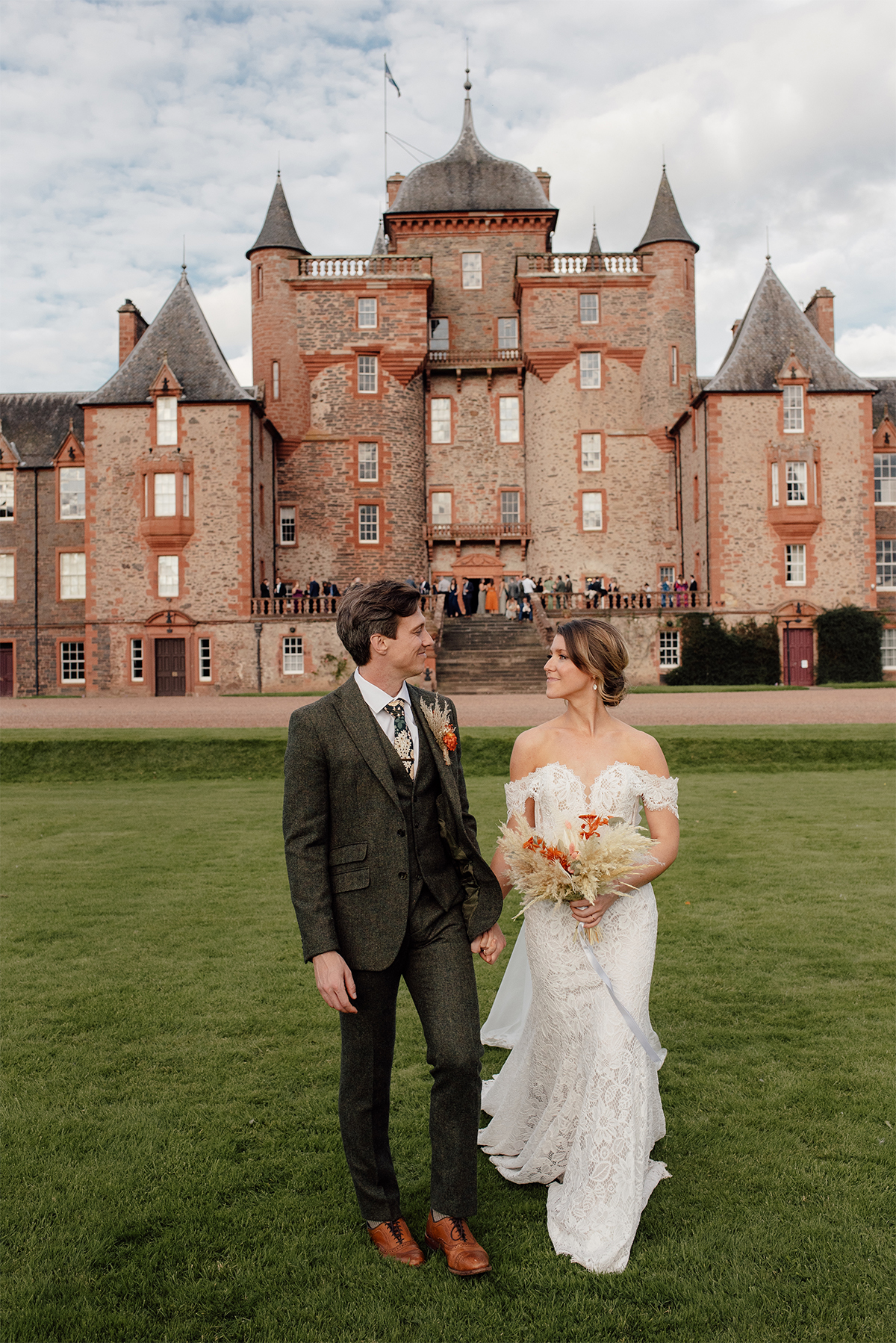 Wedding couple walking down the grounds at the Thirlestane Castle.