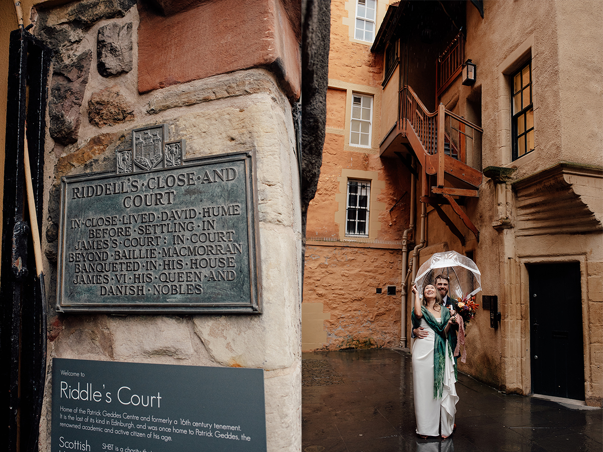 Wedding couple standing outside the yellow building, one of most unique wedding venues in Edinburgh. 