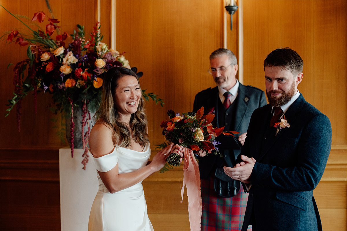 A photo of bride and room during their wedding ceremony at Riddle's Court, captured by Edinburgh photographer.