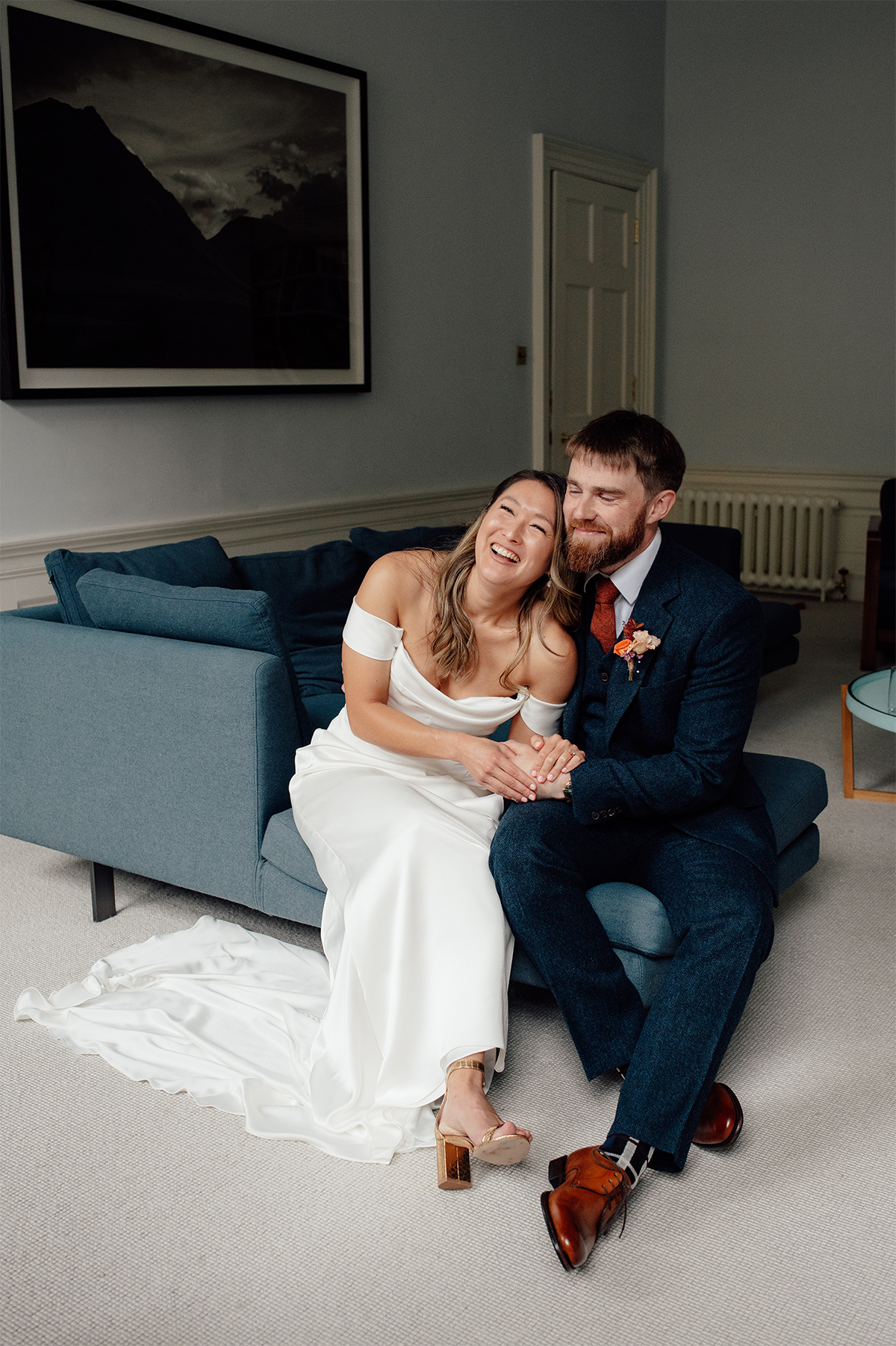 Sam and Pad sitting on the sofa and posing for Edinburgh wedding photographer on a rainy day in Scotland.