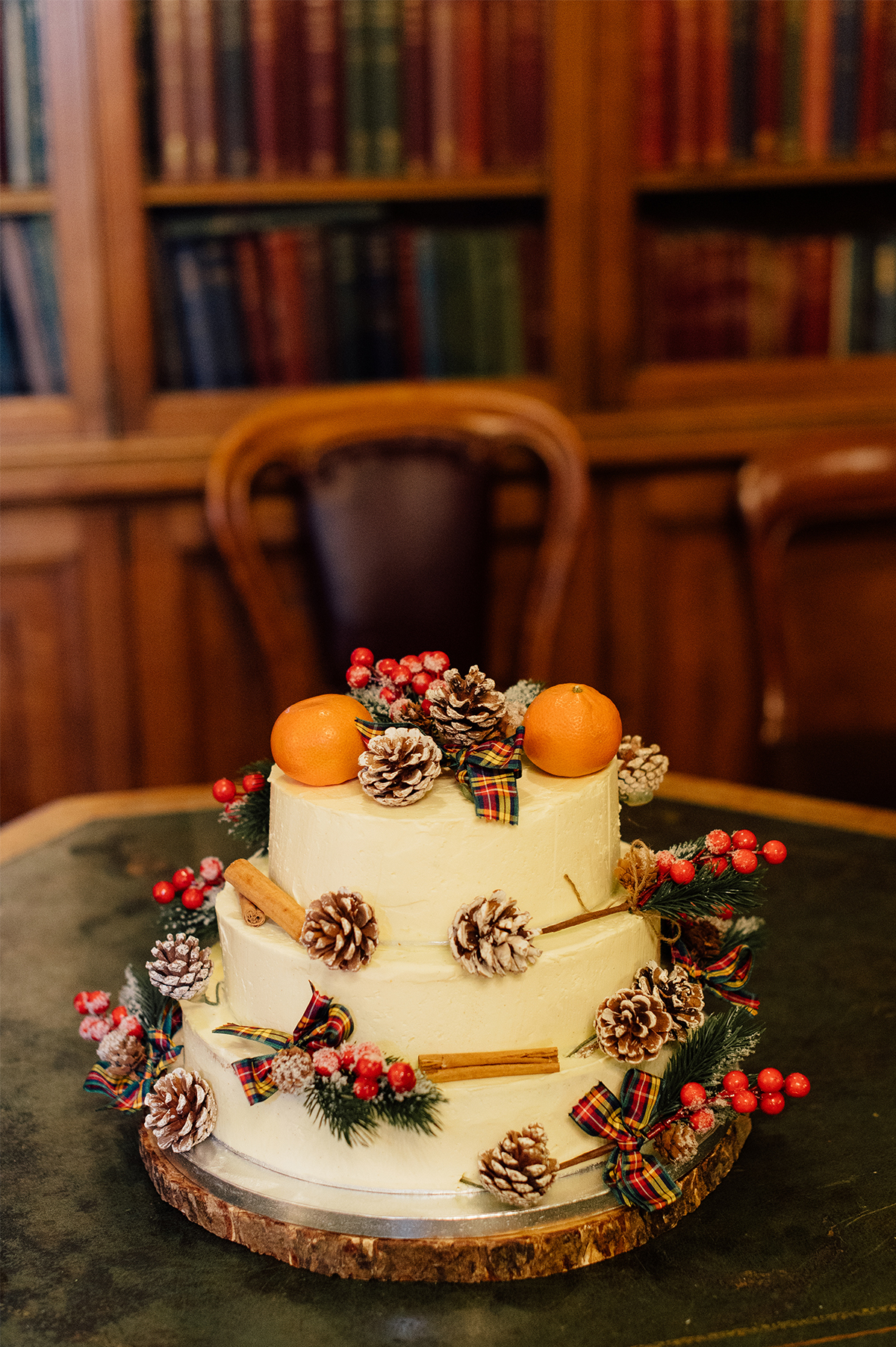 Wedding cake with pine cones and citrus on top. 