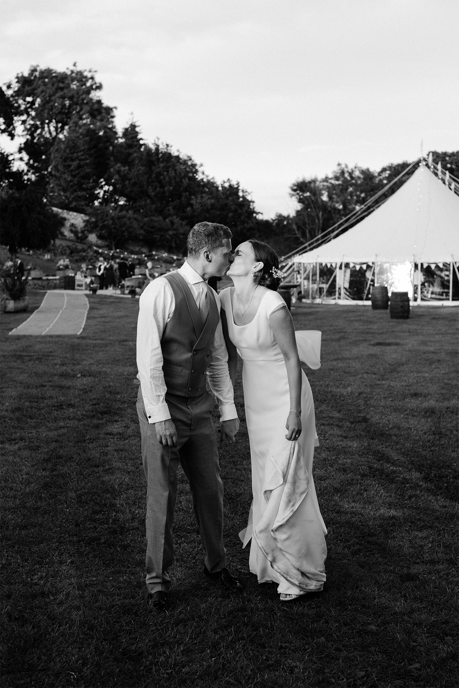 Black and white photo of bride & groom outside elegant pitches marquee.