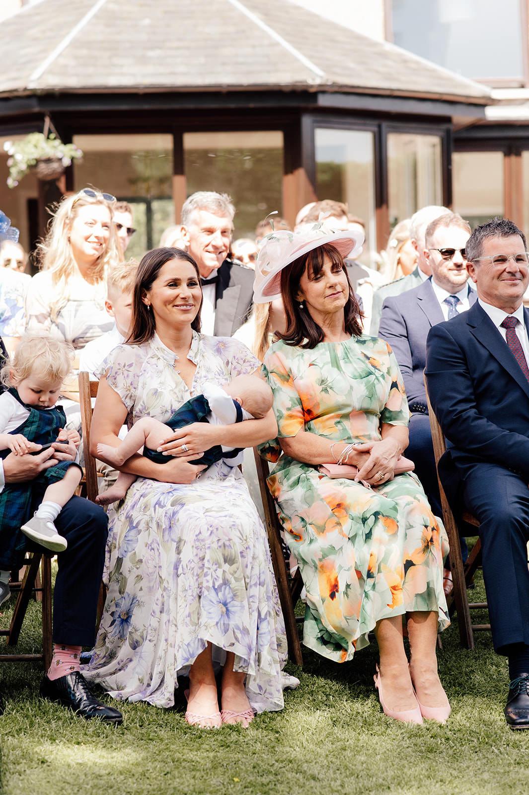 Grooms family watching wedding ceremony in the garden.
